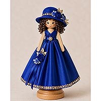 Handmade doll pin doll featuring a royal blue gown, matching decorated hat, curly brown hair, and ribbon rose embellishments displayed on a wooden stand.